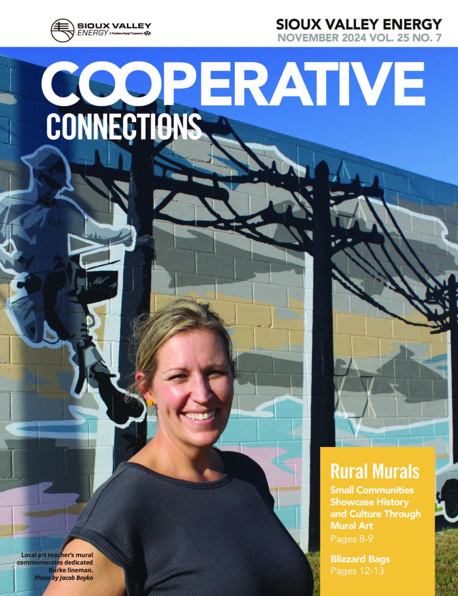 Magazine cover of woman standing in front of mural of a line worker