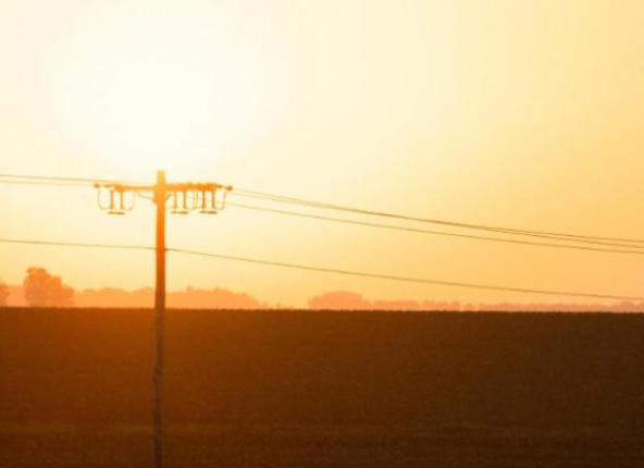 Three-phase line silhouetted by setting sun