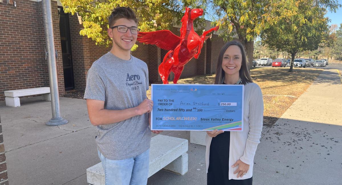Arien Staiford receives check from Carrie Vugtuveen with Sioux Valley Energy