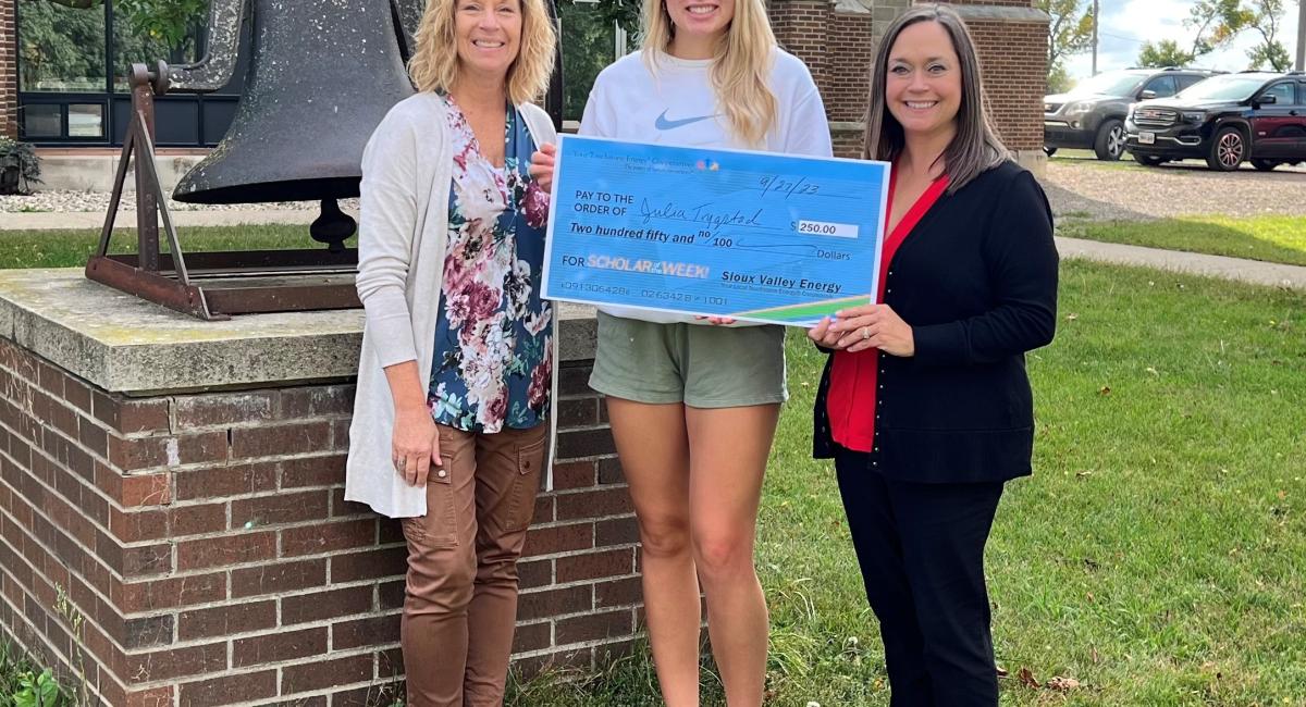 Three Women with Center Woman Holding Big Check